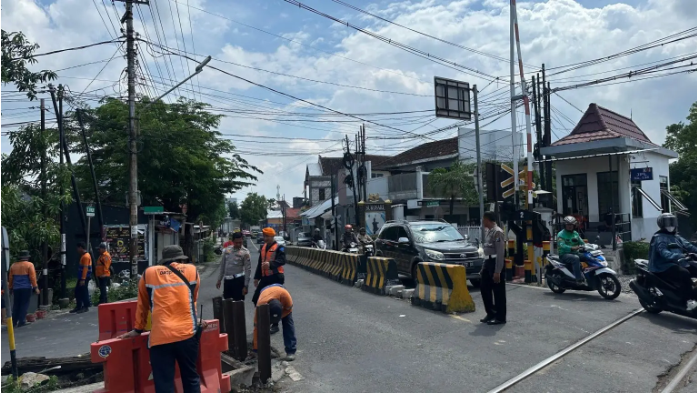 Perbaikan Tanggul Amblas , Sat Lantas Polres Madiun Kota Quick Respon Antisipasi Kemacetan di Perlintasan Kereta